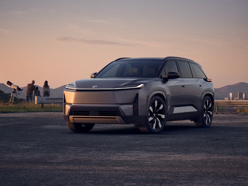 2027 Toyota Highlander Parked with family looking at the sky in the background