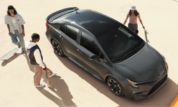 Friends getting into a dark toyota sedan