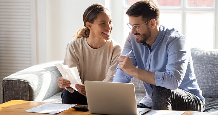 A couple filling out the pre-approval form on the laptop
